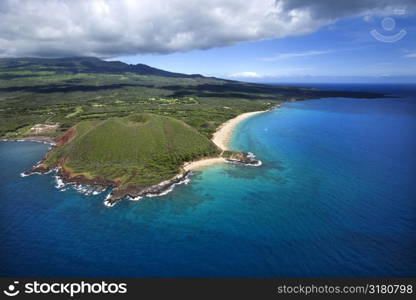 Aerial of Maui, Hawaii coastline with crater and cliffs and beach on Pacific ocean.