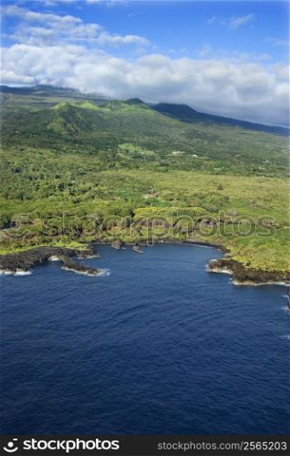 Aerial of Maui, Hawaii coastline with mountains in background.