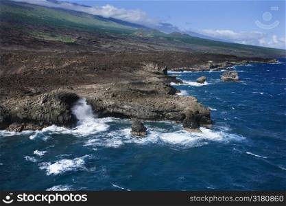 Aerial of Pacific ocean and Maui, Hawaii coast with waves hitting lava rocks.