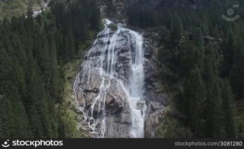 Aerial of wonderfull waterfall in the mountains with pine forest in Austian Alps