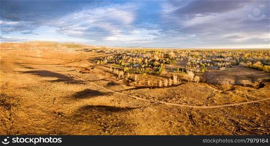aerial panorama of foothills prairie and residential areas along Front Range of Rocky Mountains near Fort Collins, Colorado, fall scenery lit by sunrise