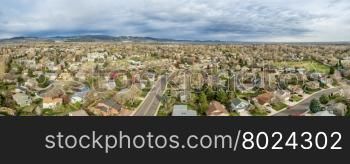 aerial panorama of Fort Collins in northern Colorado - residential buildings with Rocky Mountains foothills in background, early spring scenery