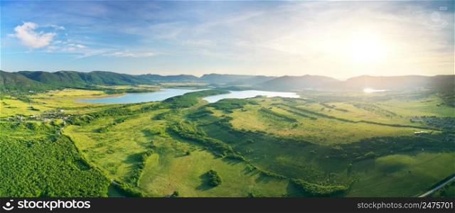 Aerial panorama of meadows, mountain and lakes. Nature landscape scene.
