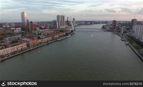 Aerial panorama of Rotterdam on the banks of the river with Erasmus Bridge over it, Netherlands. Evening scene