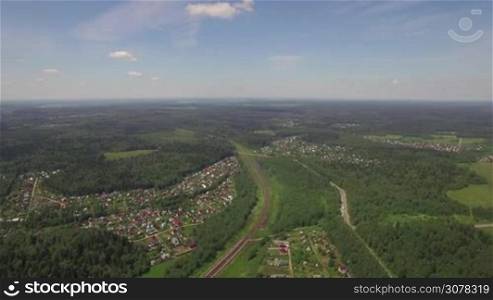 Aerial panorama of Russian countryside. Summer houses and railway among green woods