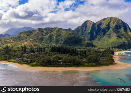 Aerial panoramic image off the coast over Tunnels beach on Hawaiian island of Kauai with Na Pali mountains behind. Aerial drone shot of Tunnels Beach on the north shore of Kauai in Hawaii