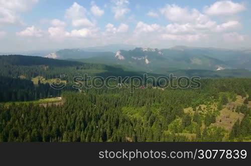 Aerial panoramic mountains landscape, beautiful summer forest and blue sky, green highlands rural scenery. 4K footage. Travel and beauty in nature concept.