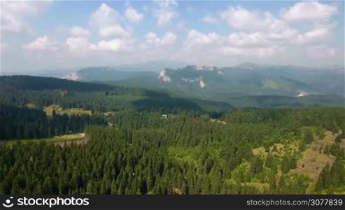 Aerial panoramic mountains landscape, beautiful summer forest and blue sky, green highlands rural scenery. 4K footage. Travel and beauty in nature concept.