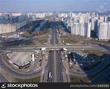 Aerial panoramic photography from the drone, bird's eye view to Pozniaky district, Mykoly Bazhana Ave with traffic and modern building of the city Kiev Ukraine at sunset .. A bird's eye view, aerial panoramic view from drone to the Kharkivskiy district of Kiev, Ukraine with highway, road junction and modern buildings.