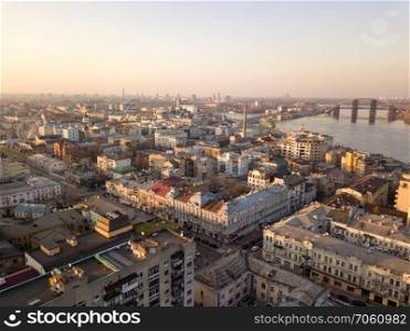 Aerial panoramic view from the drone to the oldest district of Kiev - Podol, Sahaidachnoho street, the Podolsky bridge, Havana bridge, old buildings and other historical places.. The panoramic bird’s eye view from drone to the central historical part of the city Kiev - the Podol district, the Dnieper River in Kiev, Ukraine at summer sunset.