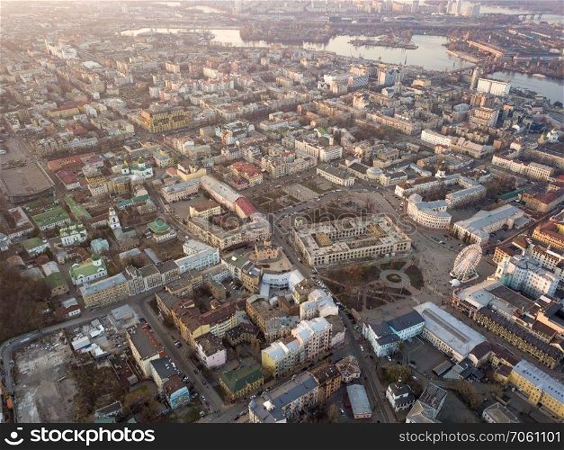 Aerial panoramic view from the drone to the oldest district of Kiev - Podol with the Kontraktova Square, Frolovsky Monastery, Havana bridge and old buildings, chuches and other historical places.. The panoramic bird&rsquo;s eye view from drone to the central historical part of the city Kiev - the Podol district, the Dnieper River in Kiev, Ukraine at summer sunset.