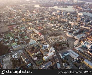 Aerial panoramic view from the drone to the oldest district of Kiev - Podol with the Kontraktova Square, Frolovsky Monastery, Havana bridge and old buildings, chuches and other historical places.. The panoramic bird&rsquo;s eye view from drone to the central historical part of the city Kiev - the Podol district, the Dnieper River in Kiev, Ukraine at summer sunset.