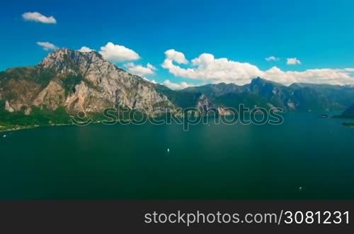 Aerial panoramic view of lake with yachts near rural area. Panoramic view with clouds and blue sky
