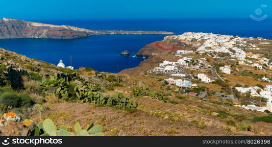 Aerial panoramic view of Oia or Ia and Finikia on the island Santorini, white houses, windmills and church with blue domes, Greece