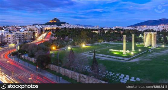 Aerial panoramic view with Ruins and a columns of the Temple of Olympian Zeus, Mount Lycabettus at night, Athens, Greece. Aerial city view in Athens, Greece