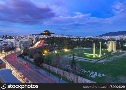 Aerial panoramic view with Ruins and a columns of the Temple of Olympian Zeus, Mount Lycabettus at night, Athens, Greece. Aerial city view in Athens, Greece