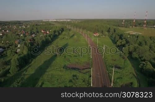 Aerial - Passenger train running in the countryside among green trees, Russia