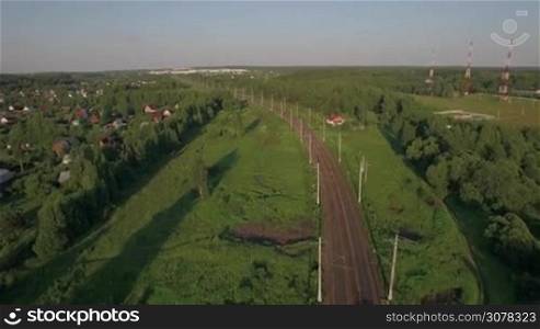 Aerial - Passenger train running in the countryside among green trees, Russia