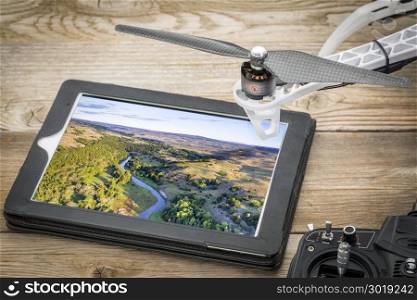 aerial photography concept - reviewing pictures of the Dismal RIver in Nebsrask on a digital tablet with a drone rotor and radio controller, screen picture copyright by the photographer