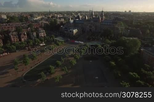 Aerial - Rijksmuseum and Art Square with I amsterdam slogan and pond. Cityscape of Dutch capital at sunset