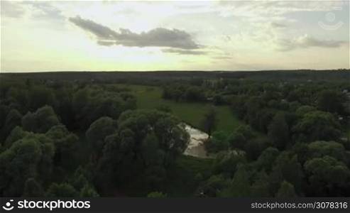 Aerial shot of green nature and summer houses at sunset. Russian countryside