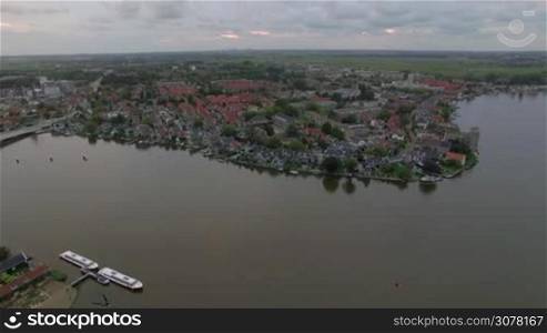Aerial shot of houses in township on the river bank in Netherlands