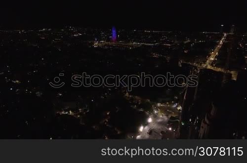 Aerial shot of night Barcelona with city lights and illuminated Torre Agbar skyscraper, Spain