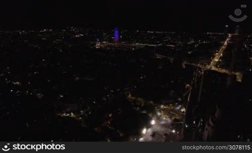 Aerial shot of night Barcelona with city lights and illuminated Torre Agbar skyscraper, Spain