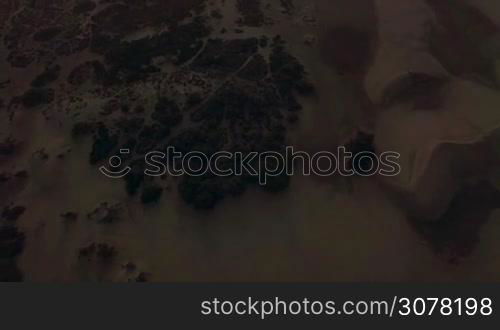 Aerial shot of picturesque sandy landscape with dunes and ocean at sunset, Gran Canaria