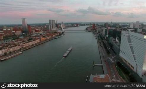 Aerial shot of Rotterdam city with view to the river, Erasmus Bridge and waterside buildings