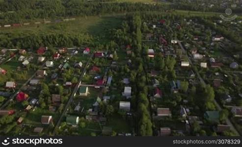 Aerial shot of Russian village and freight train traveling through it, Russia