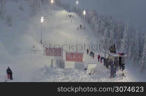 Aerial shot of ski jumping competitions on resort Ruka. Sportswoman doing somersault jumping from the hill and landing successfully