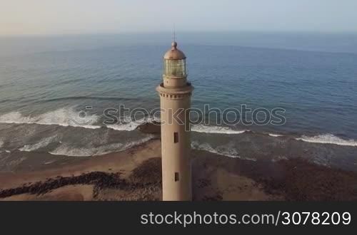 Aerial shot of the ocean and Maspalomas Lighthouse of 19th century on the coast of Gran Canaria