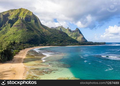 Aerial shot off the coast over Tunnels beach on Hawaiian island of Kauai with Na Pali mountains behind. Aerial drone shot of Tunnels Beach on the north shore of Kauai in Hawaii