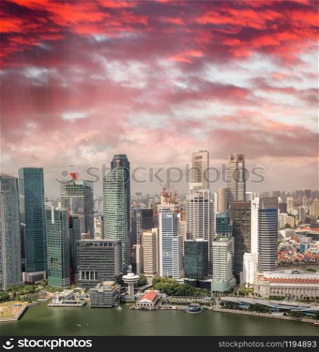 Aerial skyline of downtown skyscrapers in Singapore at sunset.