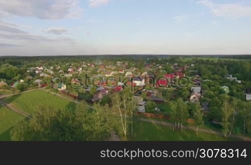 Aerial summer scene with village near the highway, green woods and fields, Russia