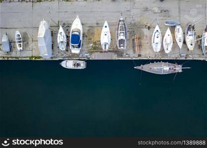 Aerial top View by Drone of yachts or small boats. Yacht and boats are moored at the quay. Parking