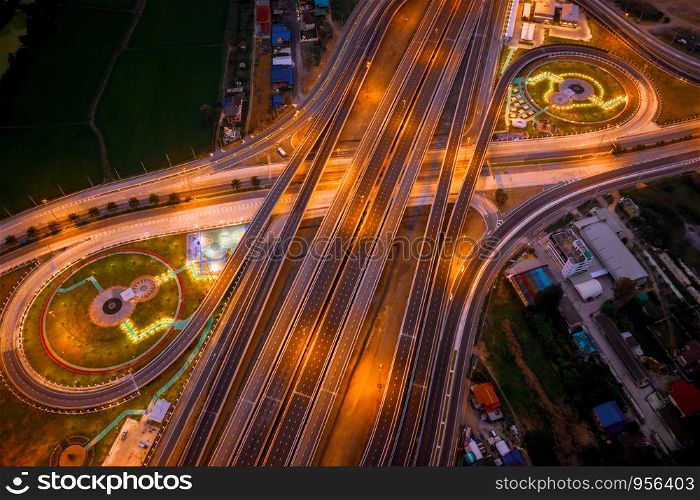 aerial top view construction of a new ring road interchange and motorway expressway bypass for cars transportation connecting the city at night in Thailand from drone camera