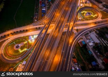 aerial top view construction of a new ring road interchange and motorway expressway bypass for cars transportation connecting the city at night in Thailand from drone camera
