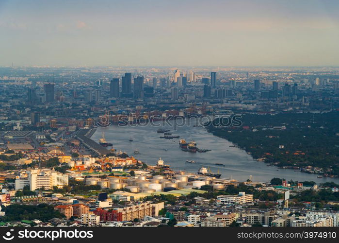 Aerial top view of container cargo ship in the export and import business and logistics international goods in urban city. Bangkok, Thailand. Shipping cargo to the harbor by crane.