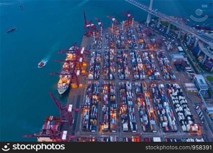 Aerial top view of container cargo ship in the export and import business and logistics international goods in urban city. Shipping to the harbor by crane in Victoria Harbour, Hong Kong City.
