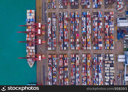 Aerial top view of container cargo ship in the export and import business and logistics international goods in urban city. Shipping to the harbor by crane in Victoria Harbour, Hong Kong City.