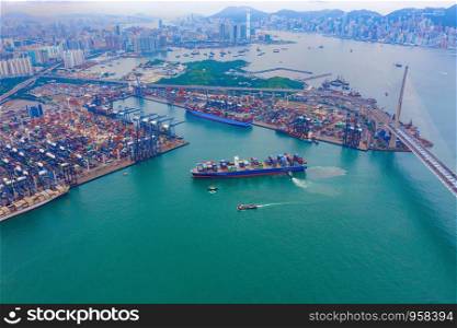 Aerial top view of container cargo ship in the export and import business and logistics international goods in urban city. Shipping to the harbor by crane in Victoria Harbour, Hong Kong City.