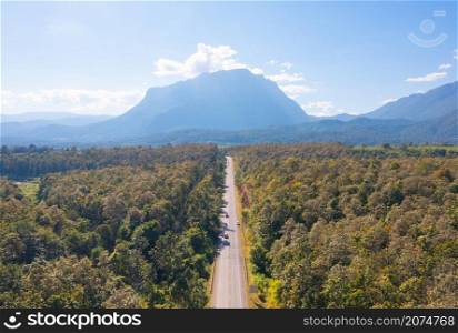Aerial top view of empty road or street to Doi Luang Chiang Dao, Chiang Mai on mountain hill with green natural forest trees in rural area, Thailand. Transportation. Nature landscape background