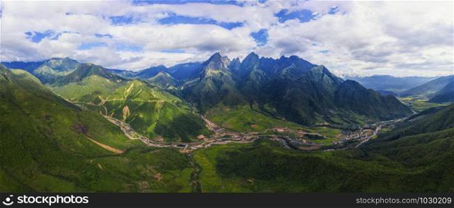 Aerial top view of Fansipan mountains with paddy rice terraces, green agricultural fields in countryside or rural area, hills valley at sunset in Asia, Sapa, Vietnam. Nature landscape background.