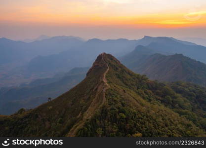 Aerial top view of forest trees and green mountain hills with fog, mist and clouds. Nature landscape background, Thailand.