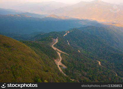 Aerial top view of forest trees and green mountain hills with fog, mist and clouds. Nature landscape background, Thailand.