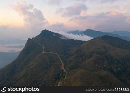 Aerial top view of forest trees and green mountain hills with fog, mist and clouds. Nature landscape background, Thailand.
