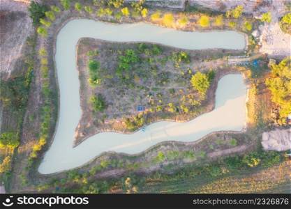 Aerial top view of forest trees, green mountain hills, and river, pond or lake. Nature landscape background, Thailand.