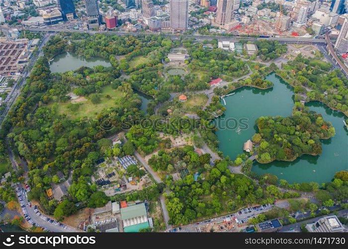 Aerial top view of green trees in Lumpini park garden and reflection. Green eco area in smart urban city at noon, Bangkok, Thailand. Environment nature landscape background.